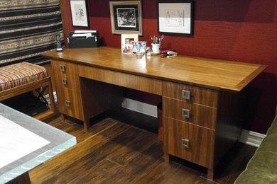 Foto de despacho actual con paredes rojas, suelo de madera oscura y escritorio independiente