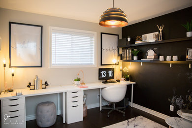 Example of a mid-sized trendy freestanding desk laminate floor and brown floor home studio design in Toronto with black walls