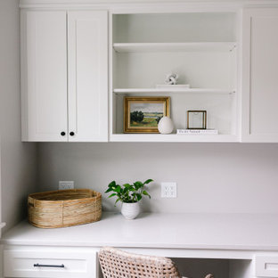 Réalisation d'un grand bureau craftsman avec un mur gris, un sol en bois clair, une cheminée double-face, un manteau de cheminée en carrelage, un bureau intégré, un sol marron et un plafond décaissé.