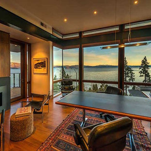 Inspiration pour un grand bureau chalet avec un mur beige, un sol en bois brun, une cheminée standard, un manteau de cheminée en métal, un bureau intégré et un sol marron.
