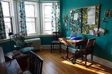 Diseño de despacho ecléctico de tamaño medio sin chimenea con paredes azules, suelo de madera clara, escritorio independiente y suelo marrón
