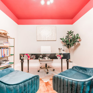 Bild på ett mellanstort retro hemmabibliotek, med rosa väggar, heltäckningsmatta, ett fristående skrivbord och grått golv