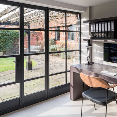 Inspiration for a mid-sized farmhouse built-in desk ceramic tile study room remodel in Other with white walls