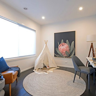 Contemporary study room in Melbourne with white walls, dark hardwood floors, a freestanding desk and black floor.