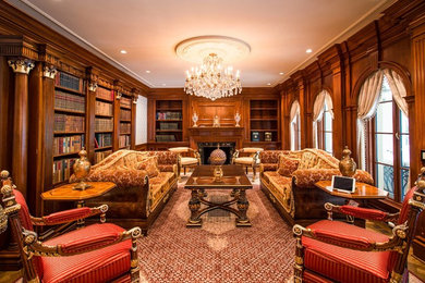 ワシントンD.C.にある中くらいなおしゃれな書斎 (茶色い壁、無垢フローリング、標準型暖炉、自立型机、石材の暖炉まわり) の写真