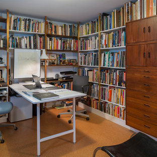 Foto på ett litet funkis hemmastudio, med ett inbyggt skrivbord, vita väggar och korkgolv