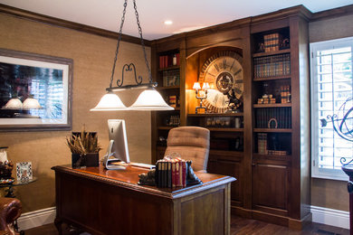 Diseño de despacho rústico grande con paredes beige, suelo de madera oscura, escritorio independiente y suelo marrón