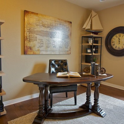 Example of a classic freestanding desk dark wood floor home office design in Austin with beige walls