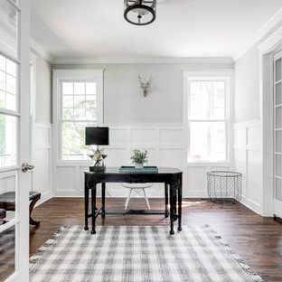 Mittelgroßes Klassisches Arbeitszimmer mit Arbeitsplatz, grauer Wandfarbe, freistehendem Schreibtisch, braunem Boden, dunklem Holzboden und vertäfelten Wänden in Richmond