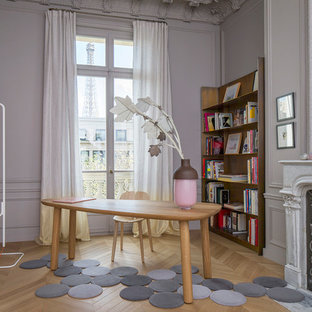 Idée de décoration pour un bureau tradition avec un mur gris, un sol en bois clair, une cheminée standard, un bureau indépendant et un sol marron.