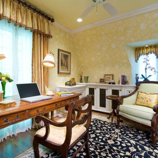 Idée de décoration pour un petit bureau tradition avec un mur jaune, un sol en bois brun et un bureau indépendant.
