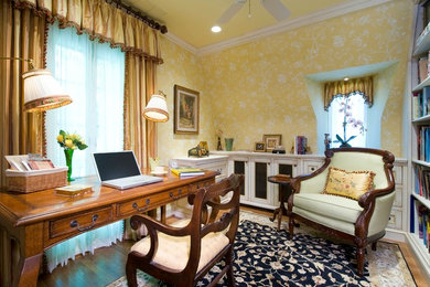 Small elegant freestanding desk medium tone wood floor study room photo in Other with yellow walls