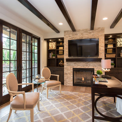 Inspiration for a mediterranean freestanding desk medium tone wood floor study room remodel in Seattle with white walls, a standard fireplace and a stone fireplace