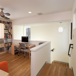 Example of a trendy freestanding desk medium tone wood floor home office design in Austin with white walls