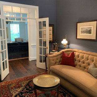 Kleines Klassisches Lesezimmer mit blauer Wandfarbe, braunem Holzboden, braunem Boden und vertäfelten Wänden in Houston