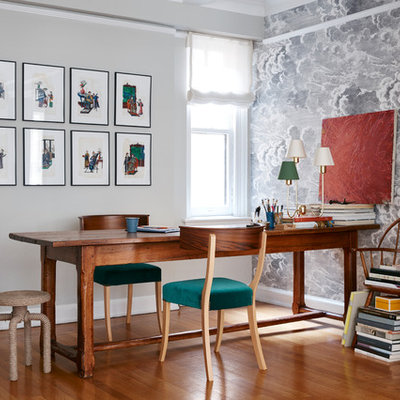 Eclectic freestanding desk medium tone wood floor study room photo in New York with gray walls and no fireplace
