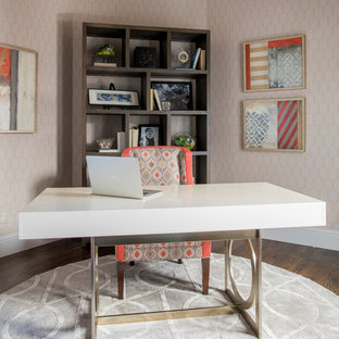 Inspiration för ett mellanstort funkis hemmabibliotek, med mörkt trägolv, ett fristående skrivbord och orange väggar