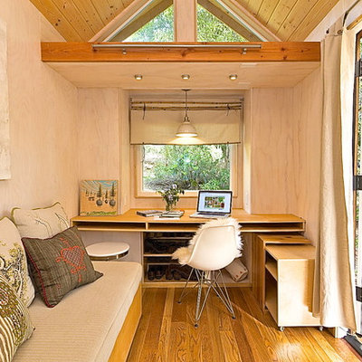 Small trendy built-in desk medium tone wood floor study room photo in Los Angeles with beige walls and no fireplace