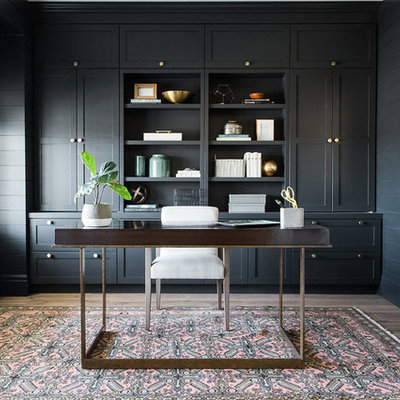 Home office - transitional freestanding desk dark wood floor home office idea in Salt Lake City with black walls