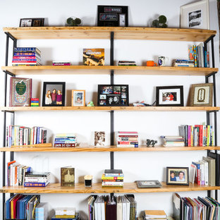 Inredning av ett stort hemmabibliotek, med vita väggar, heltäckningsmatta, ett inbyggt skrivbord och grönt golv