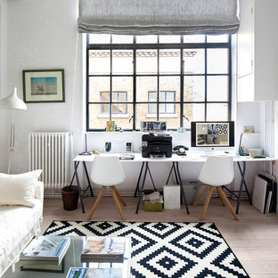 Medium sized scandinavian home office in London with white walls, light hardwood flooring, brown floors and a freestanding desk.