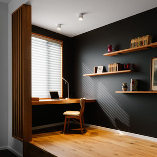 Mid-sized contemporary study room in Adelaide with black walls, a built-in desk, brown floor and light hardwood floors.