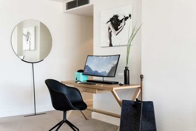 Modelo de despacho moderno pequeño con paredes blancas, moqueta, escritorio independiente y suelo beige