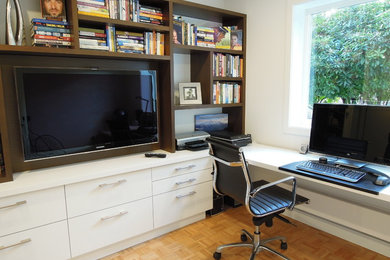 Imagen de despacho actual de tamaño medio con paredes blancas, suelo de madera clara y escritorio empotrado