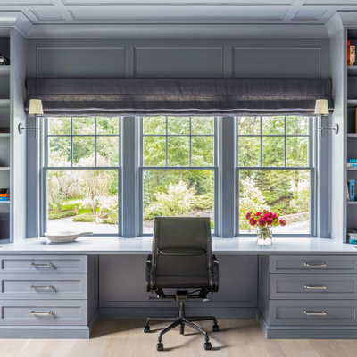 Example of a mid-sized classic built-in desk light wood floor and brown floor study room design in New York with gray walls and no fireplace