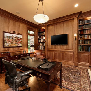 Idee per un grande studio tradizionale con libreria, parquet scuro e scrivania autoportante
