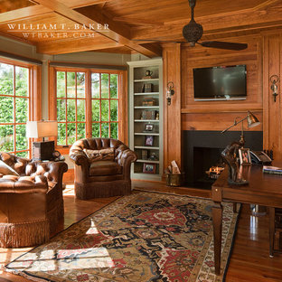 Mittelgroßes Klassisches Lesezimmer mit brauner Wandfarbe, braunem Holzboden, Kamin, freistehendem Schreibtisch, Kaminumrandung aus Holz und braunem Boden in Atlanta