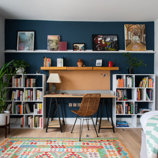 Mittelgroßes Modernes Arbeitszimmer mit Arbeitsplatz, hellem Holzboden, freistehendem Schreibtisch, weißer Wandfarbe und beigem Boden in London