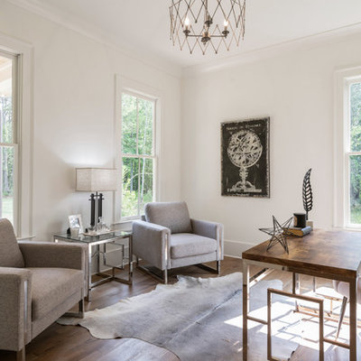 Country freestanding desk medium tone wood floor and brown floor home office photo in Atlanta with white walls