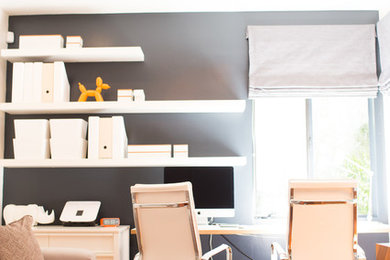 Immagine di un ufficio di medie dimensioni con parquet chiaro, scrivania incassata e pareti grigie