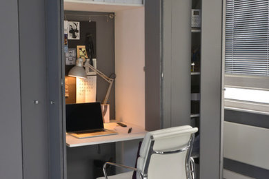 Идея дизайна: маленький кабинет в современном стиле с серыми стенами, встроенным рабочим столом и серым полом для на участке и в саду