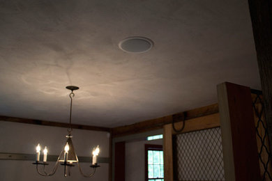 Diseño de cine en casa cerrado clásico con paredes beige, suelo de madera en tonos medios y televisor colgado en la pared