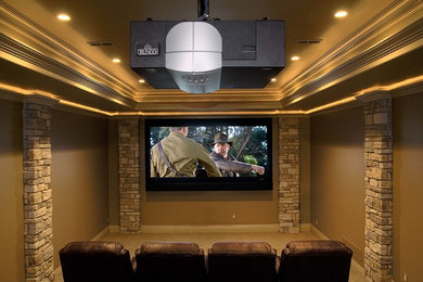 Diseño de cine en casa tradicional de tamaño medio con paredes beige, moqueta y pantalla de proyección