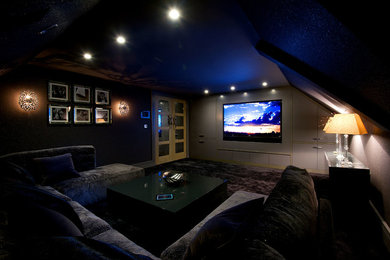 Bild på ett funkis hemmabio, med grå väggar, heltäckningsmatta och en inbyggd mediavägg
