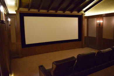 Imagen de cine en casa cerrado tradicional grande con paredes marrones, moqueta, pantalla de proyección y suelo beige