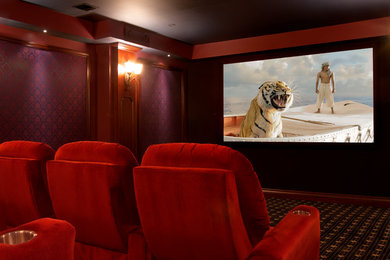 Cette photo montre une grande salle de cinéma chic fermée avec un mur multicolore, moquette, un écran de projection et un sol marron.