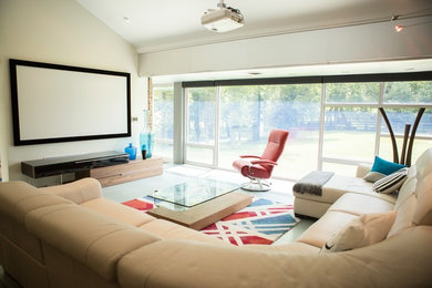 Ejemplo de cine en casa cerrado minimalista de tamaño medio con paredes beige, moqueta y pantalla de proyección