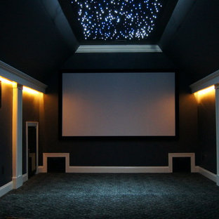 Example of a mid-sized minimalist enclosed carpeted home theater design in Other with gray walls and a projector screen