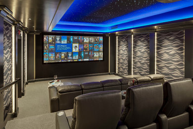 This is an example of a large classic enclosed home cinema in Boston with grey walls, carpet, a projector screen, grey floors and feature lighting.