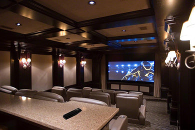 Diseño de cine en casa cerrado tradicional grande con paredes beige, moqueta y pantalla de proyección