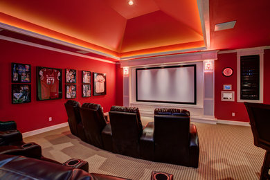 На фото: домашний кинотеатр среднего размера в современном стиле с красными стенами, ковровым покрытием и проектором