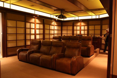 Modelo de cine en casa cerrado tradicional grande con paredes marrones, moqueta, pantalla de proyección y suelo amarillo