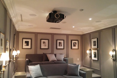 Imagen de cine en casa cerrado clásico de tamaño medio con paredes grises, pantalla de proyección y suelo gris