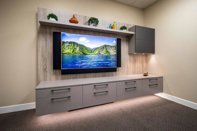 Diseño de cine en casa abierto actual de tamaño medio con paredes beige, moqueta, televisor colgado en la pared y suelo multicolor