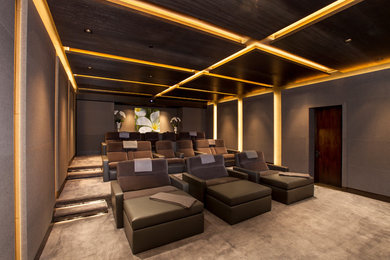 Diseño de cine en casa cerrado contemporáneo grande con paredes marrones, moqueta, pantalla de proyección y suelo marrón