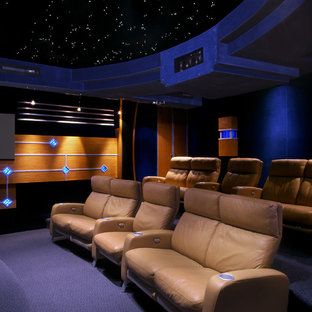 Foto de cine en casa cerrado, actual, extra grande, con paredes negras, moqueta, pantalla de proyección y suelo azul